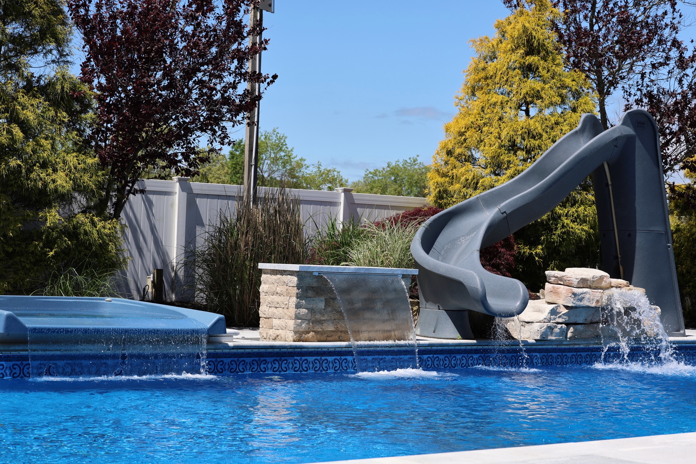 Resort-style pool with spa, waterfall, and waterslide